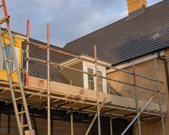 construction scaffolding surrounding a building with a new roof installation showcasing 7 levels of detail